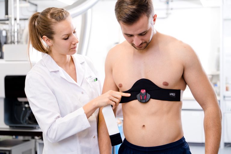 Eine Frau, die Körpersensoren bei einem Mann einstellt.