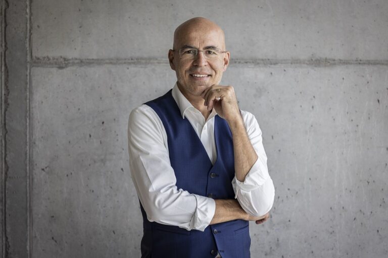 Ein Foto von dem Mann Peter Frischknecht, Stv. Geschäftsführer, sowie Leiter Campus und Start-up-Förderung, vor einer grauen Wand.