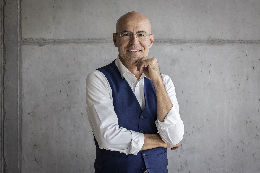 Ein Foto von dem Mann Peter Frischknecht, Stv. Geschäftsführer, sowie Leiter Campus und Start-up-Förderung, vor einer grauen Wand.