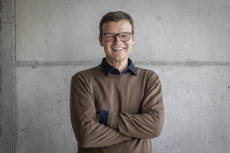 Ein Foto von dem Mann Urs Sidler, Leiter Innovation Center, vor einer grauen Wand.