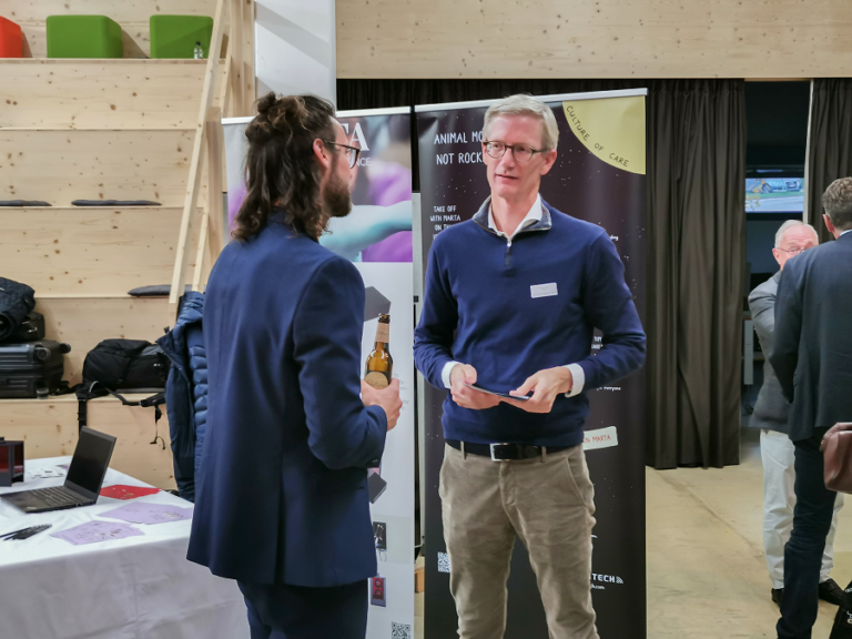 Ein Bild von zwei Männer, die sich während dem Investorsforum unterhalten.